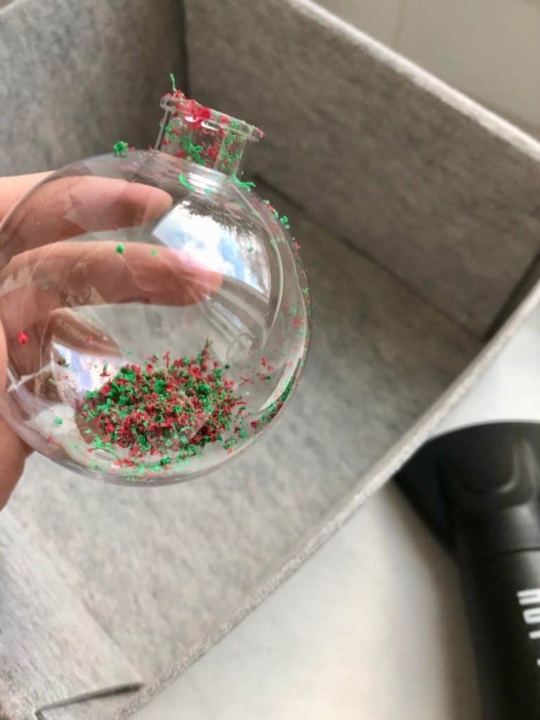 Adding crayon shavings into empty clear tree ornament