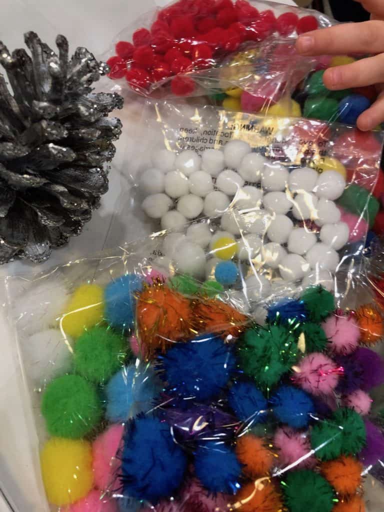 Toddler choosing colorful pom poms for kids craft time