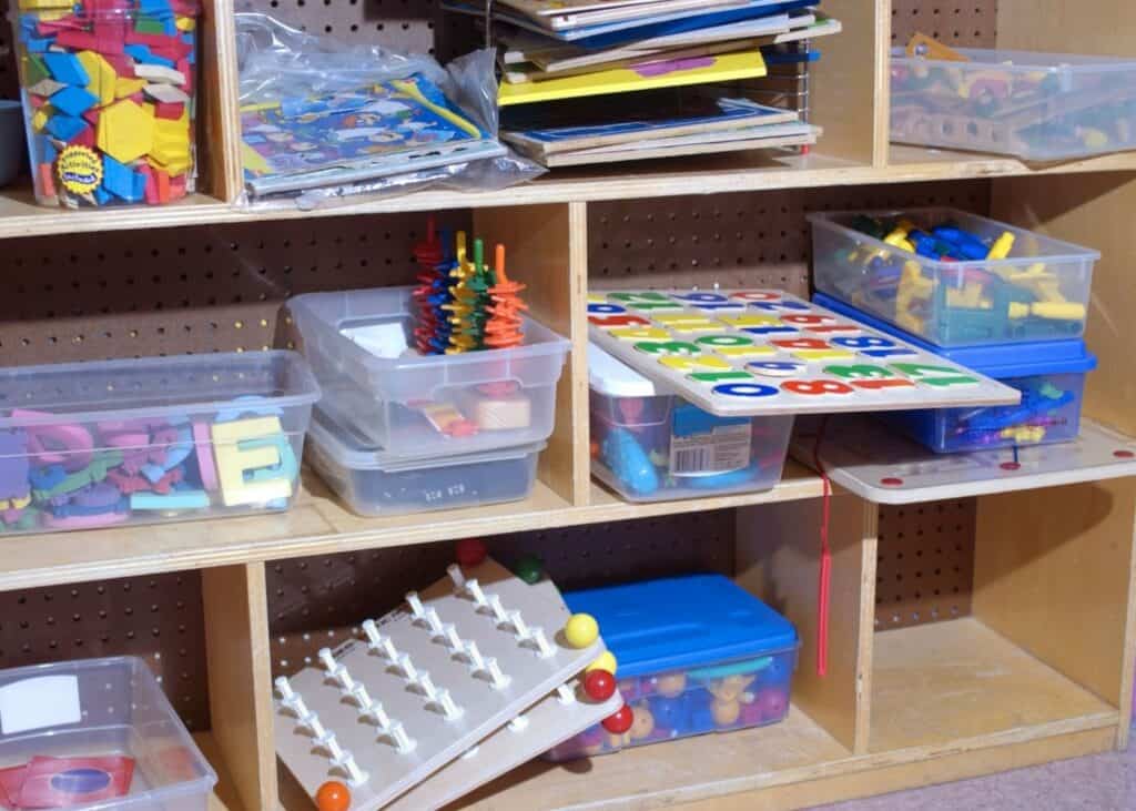 Organization tools for home - storage bins for children's toys on a wood shelf.