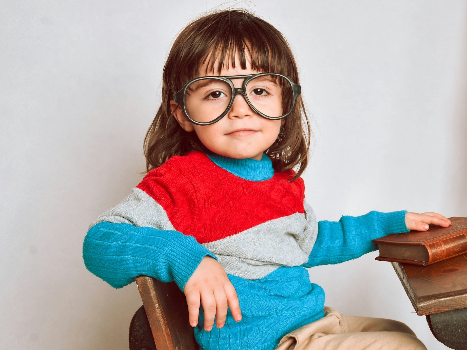Child in colorful sweater, sitting at desk