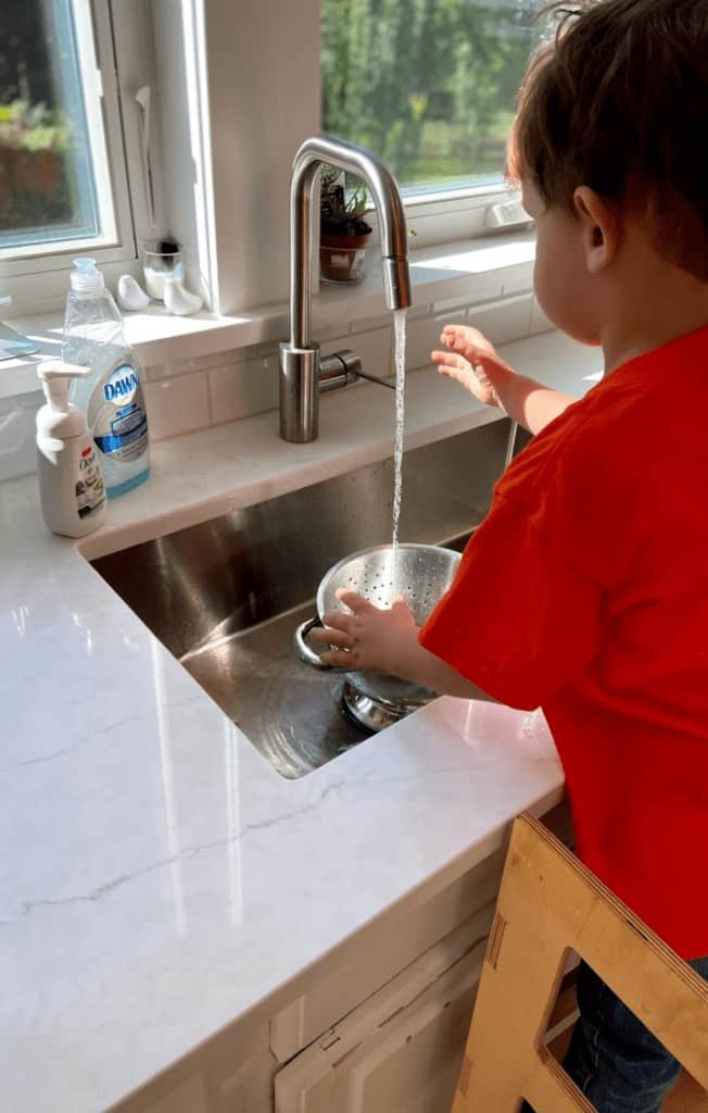 Montessori friendly kitchen child washing vegetables