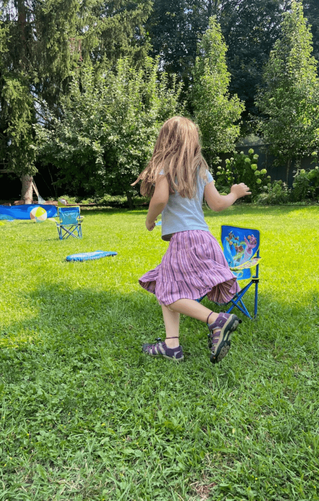 child running around a chair outside