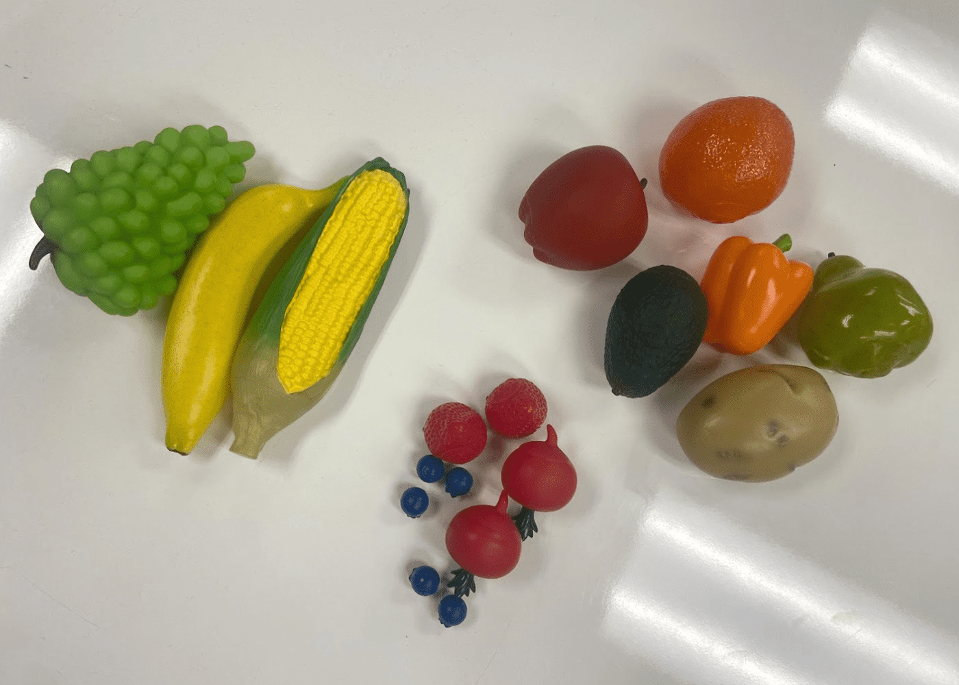 plastic fruits and vegetables sorted into categories based on size (small, medium, large)