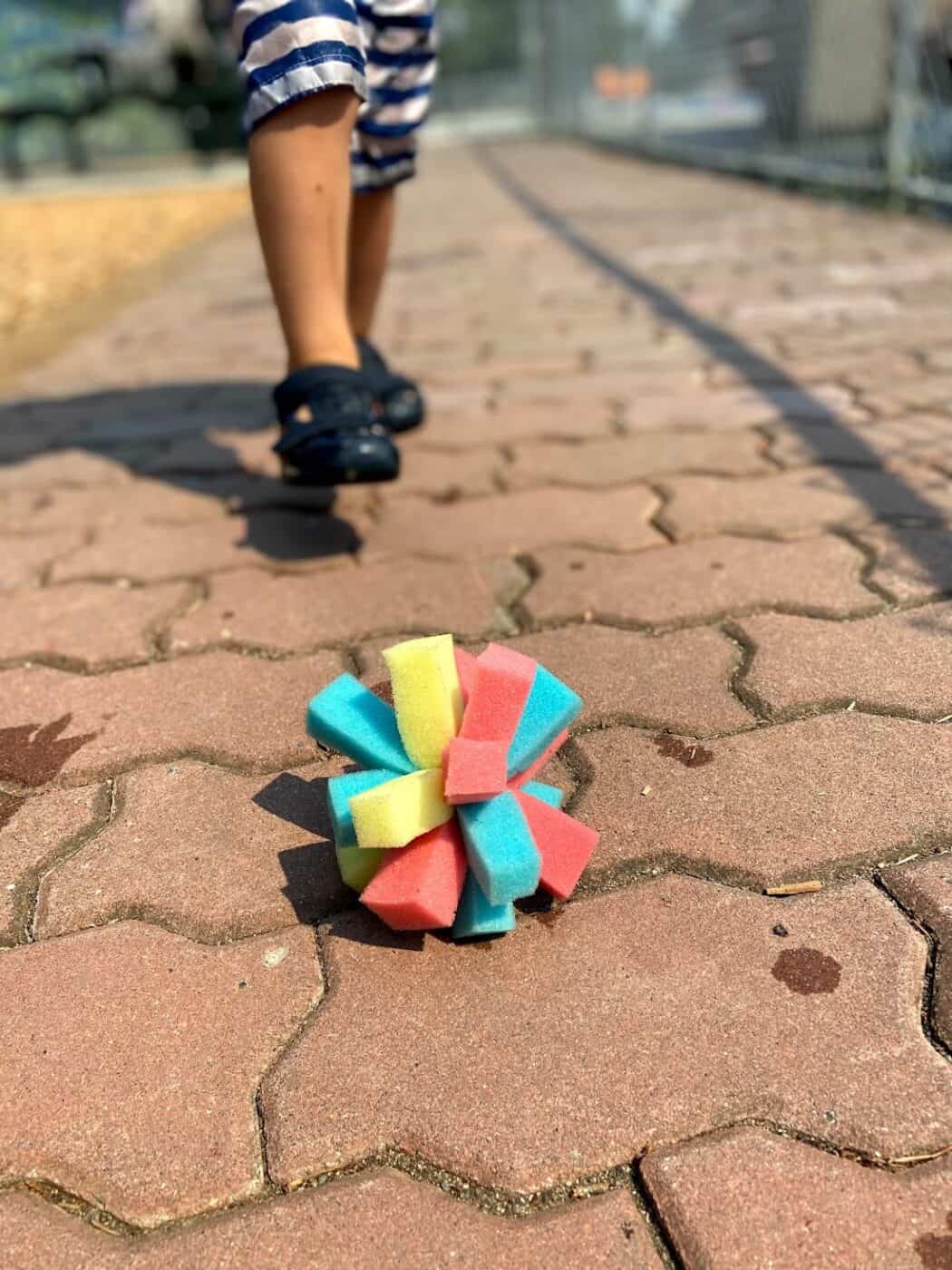 Child walking towards a blue, red, and yellow star made of sponges.