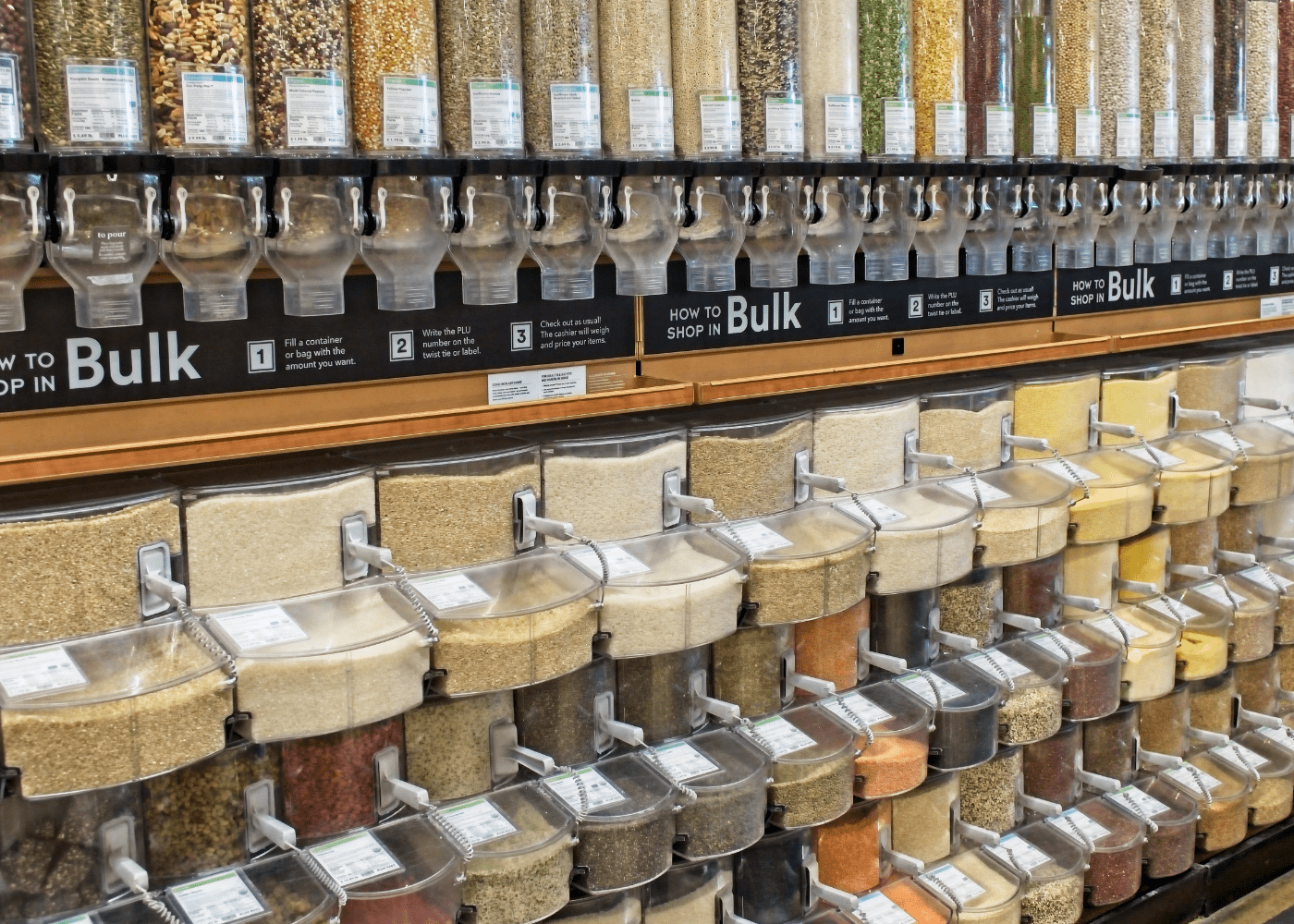 Bulk food containers in a store with four rows of food.