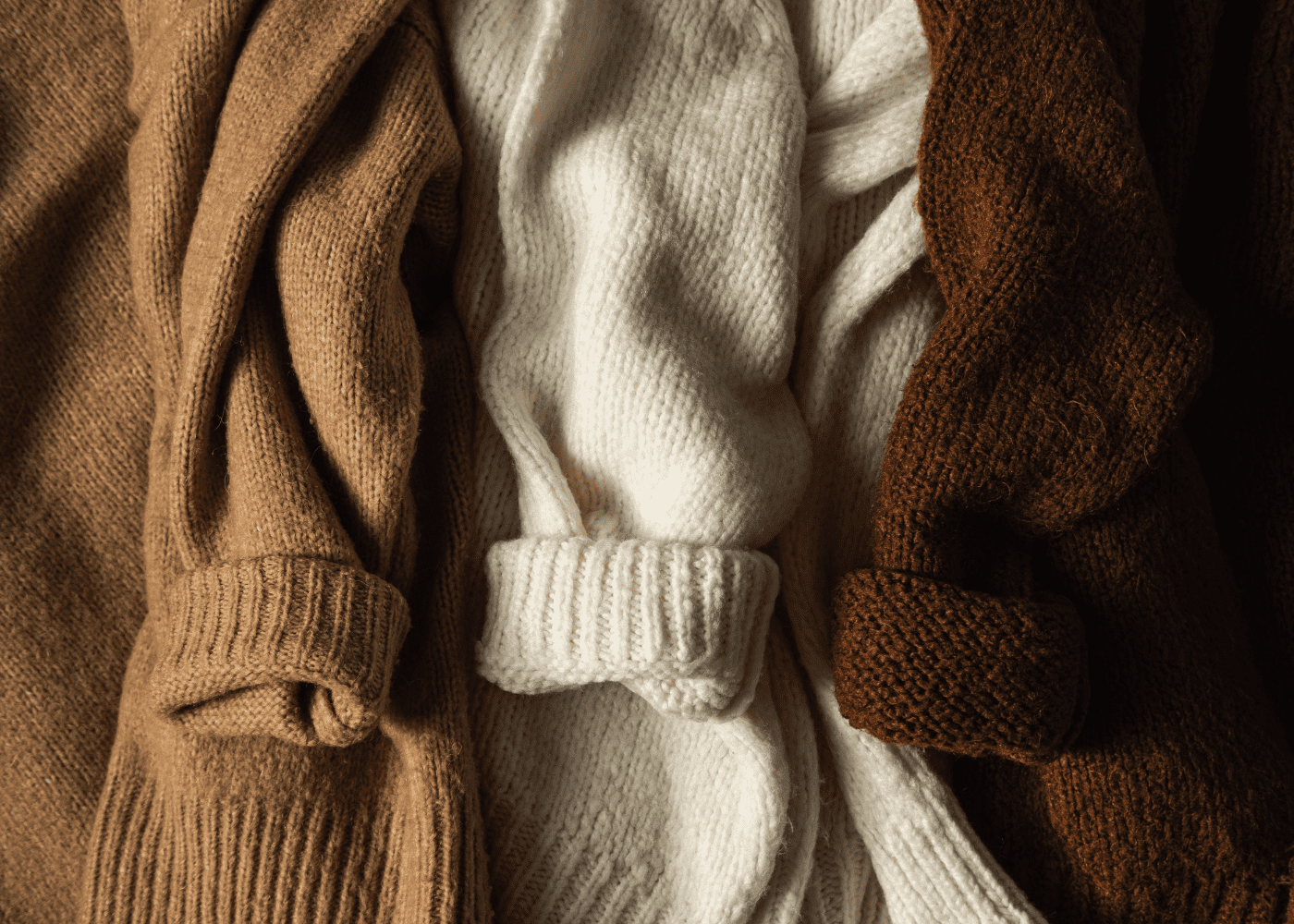 Three sweaters of varying hues of brown.