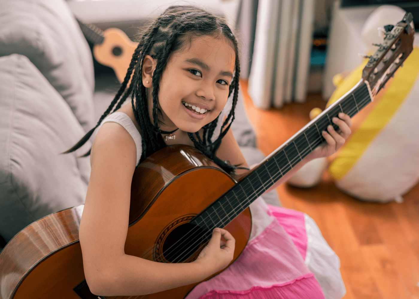 A young girl holding a guitar.