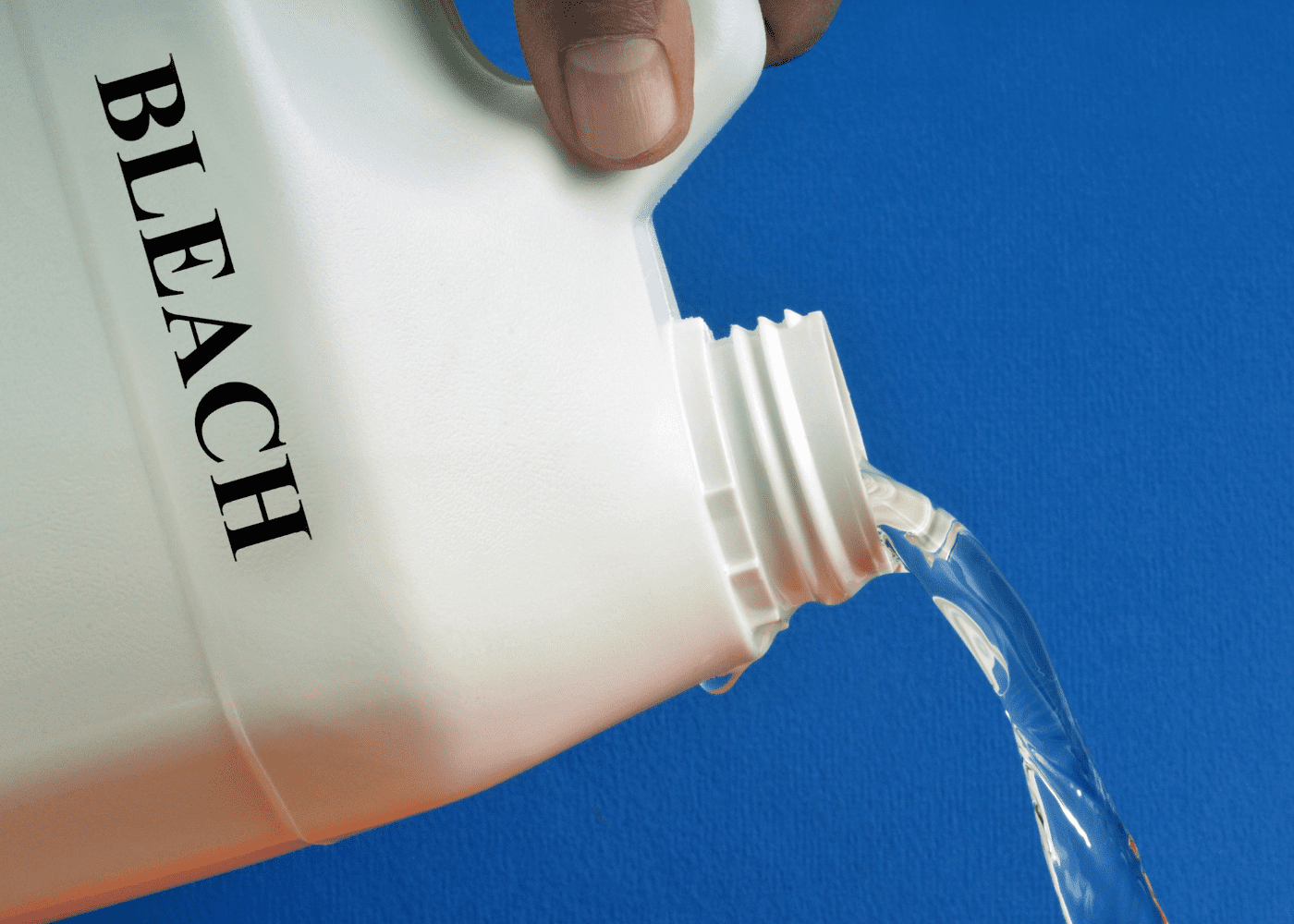 A bottle of bleach being poured.