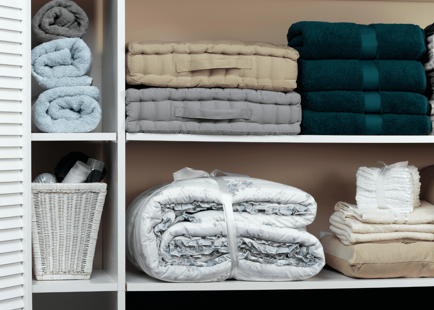 A linen closet with folded towels and other bedding items.