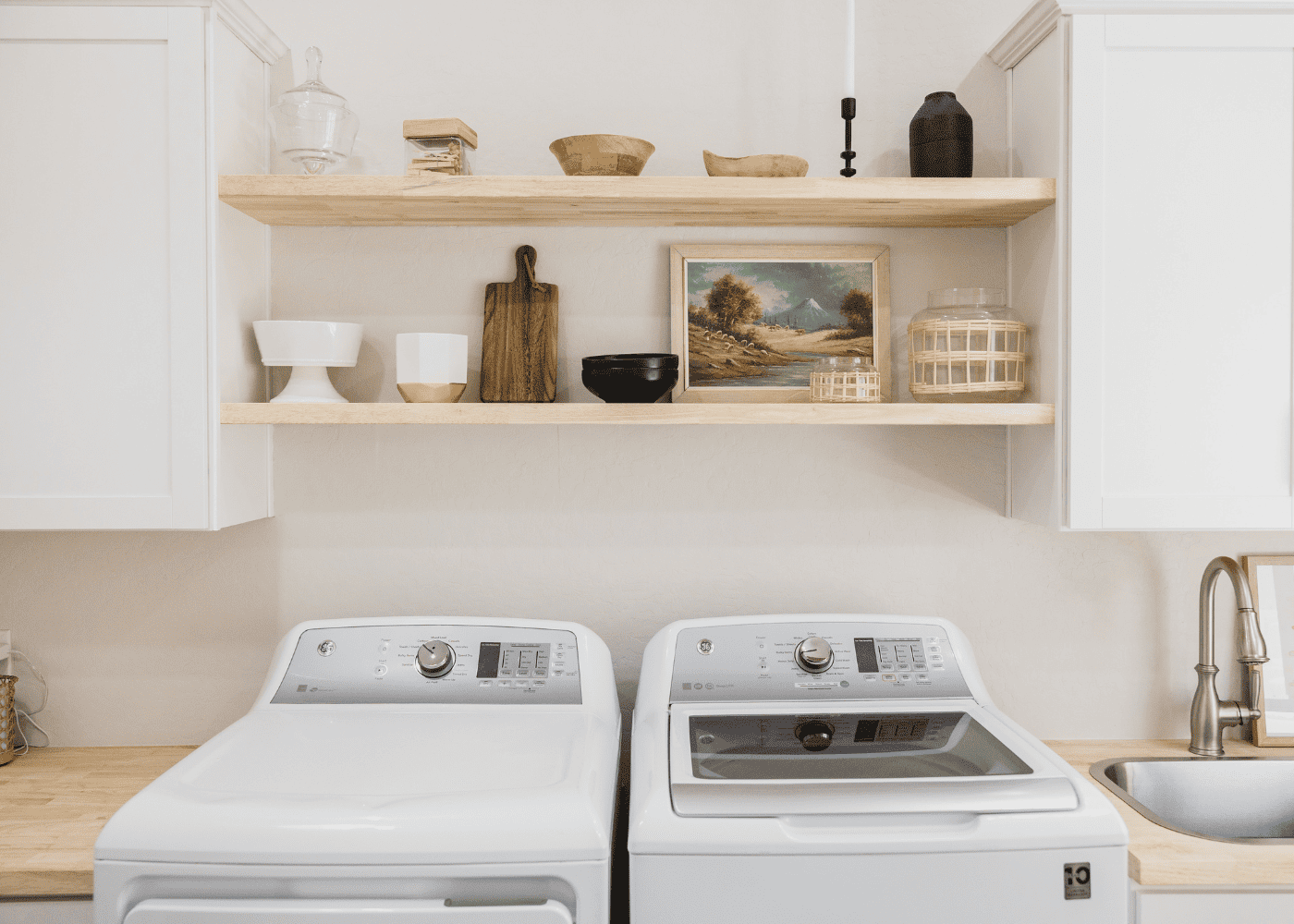 A bright laundry room with two shelves installed for storage.