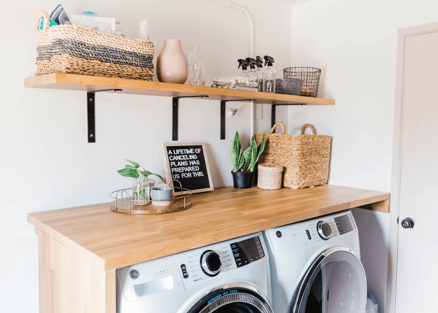 A laundry room with shelving and rattan baskets for storage.