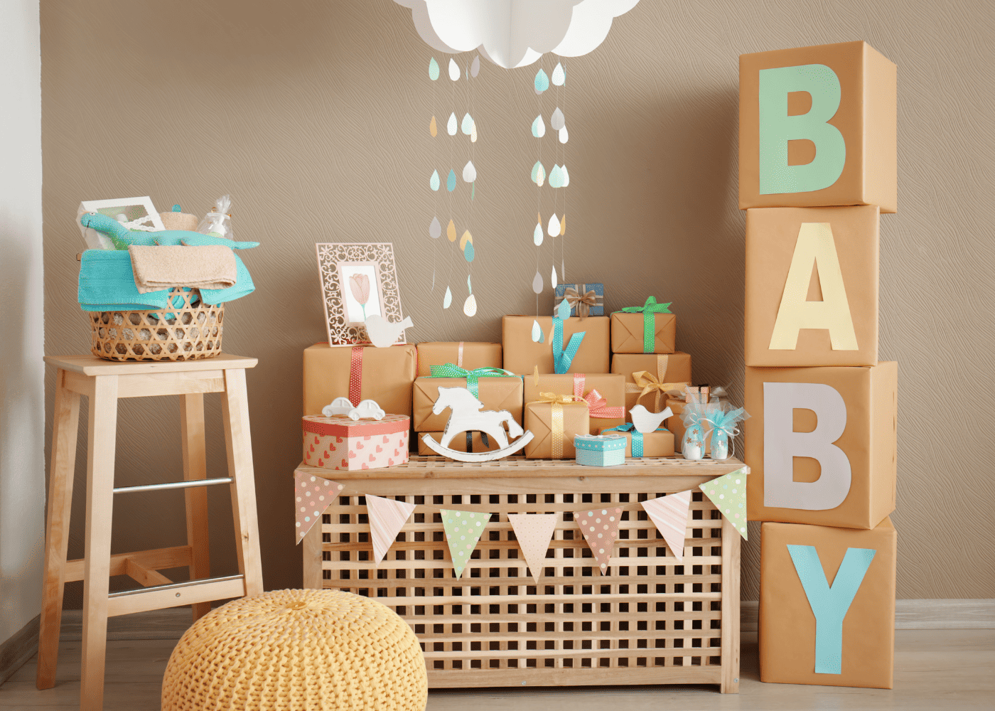 A table of presents at a baby shower with boxes on the right that spell "baby. "