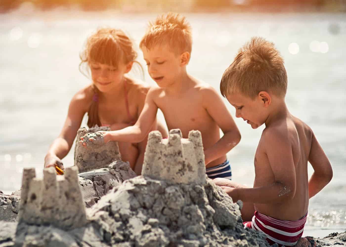 Kids at the beach working on a sand castle